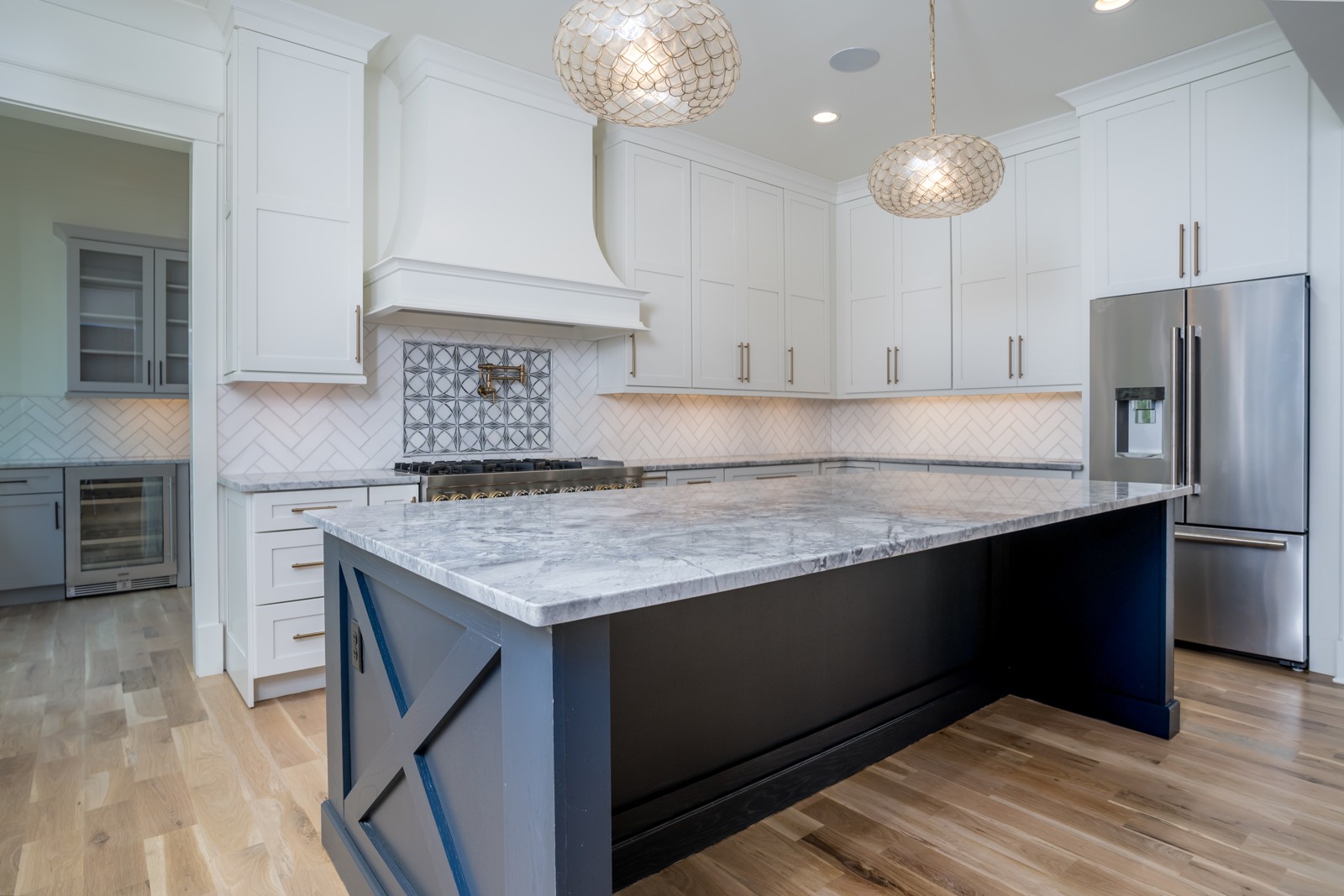 Custom white kitchen with dark island and decorative backsplash