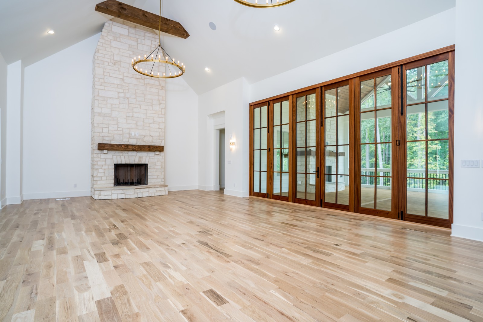 Bright living room with stone fireplace and wood-framed glass doors