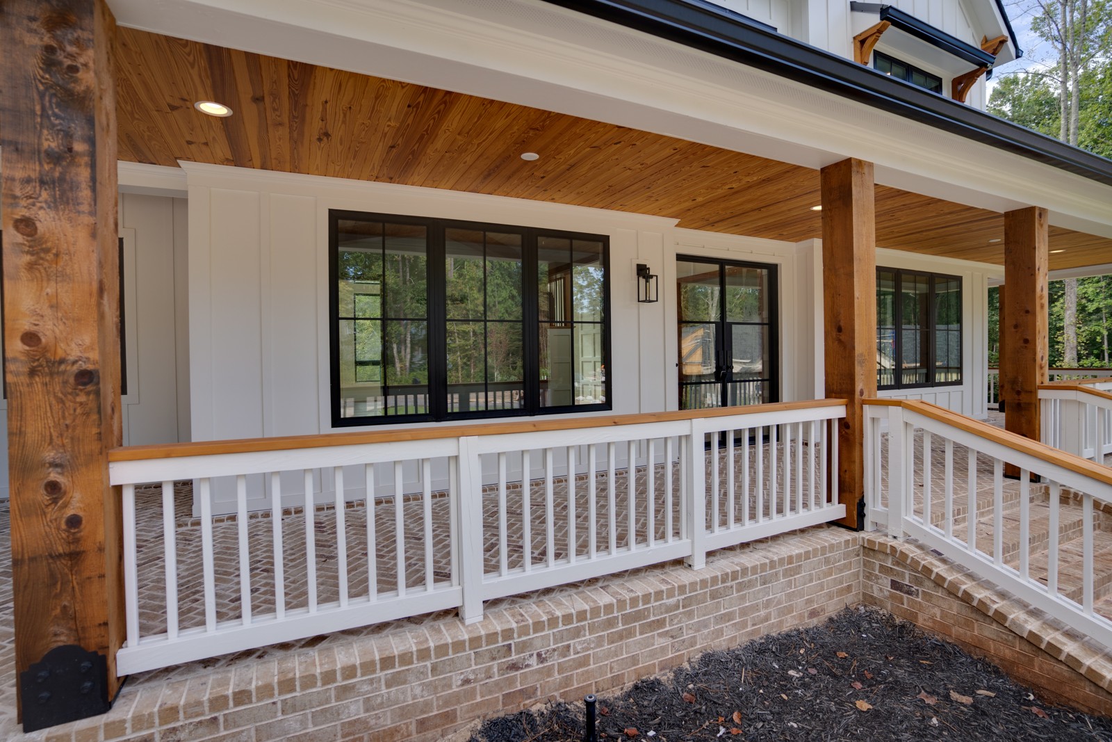 Covered front porch with wood ceiling and brick floor