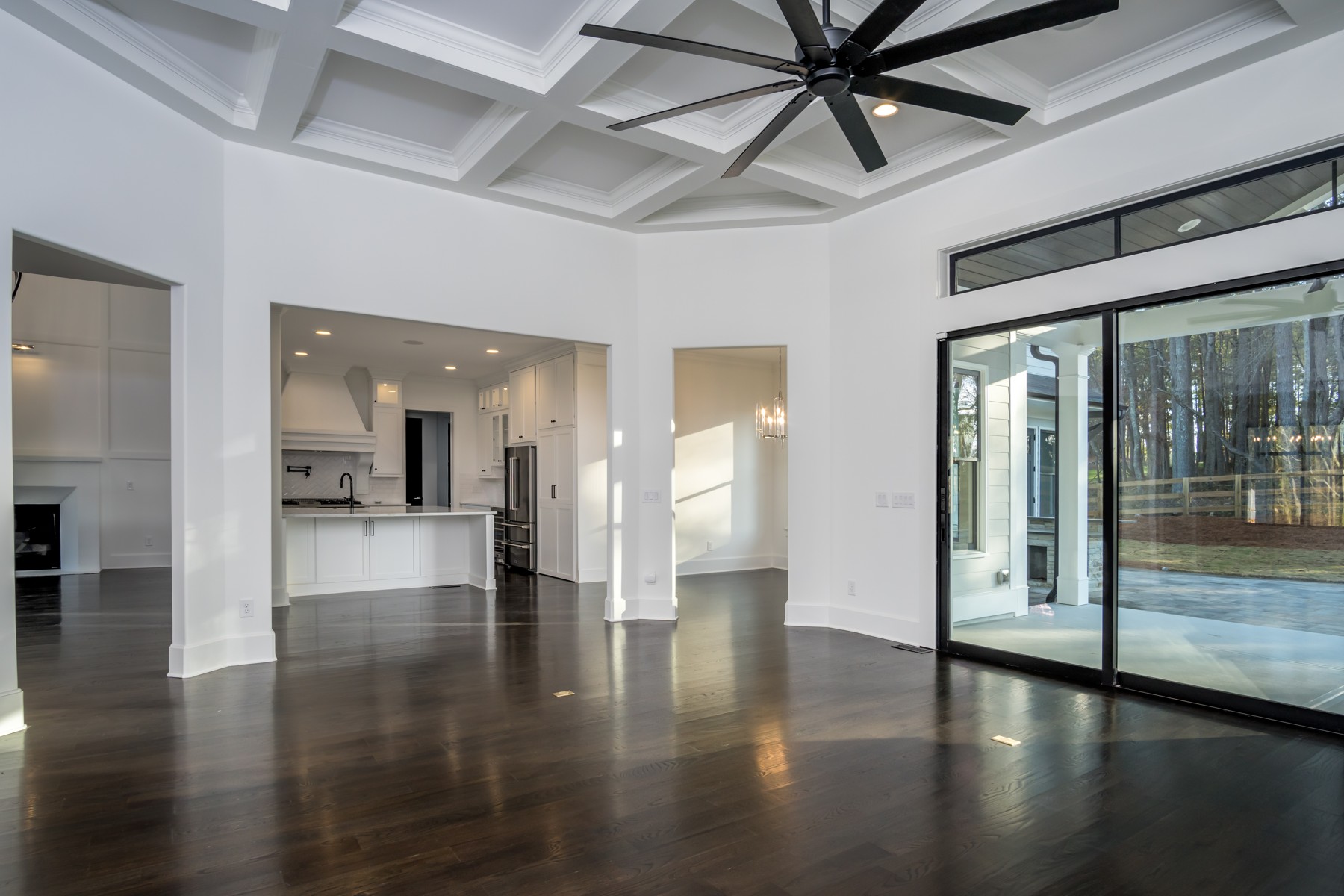 Open living space with coffered ceiling and expansive glass doors