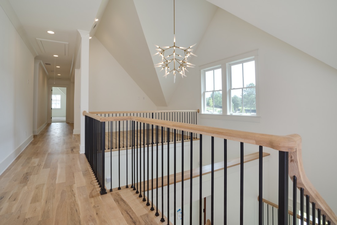 Crafted oak stair railing and an airy upstairs landing
